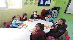 روضة مدارس النظم الحديثة تجمع أطفالها على طبق غذائي
